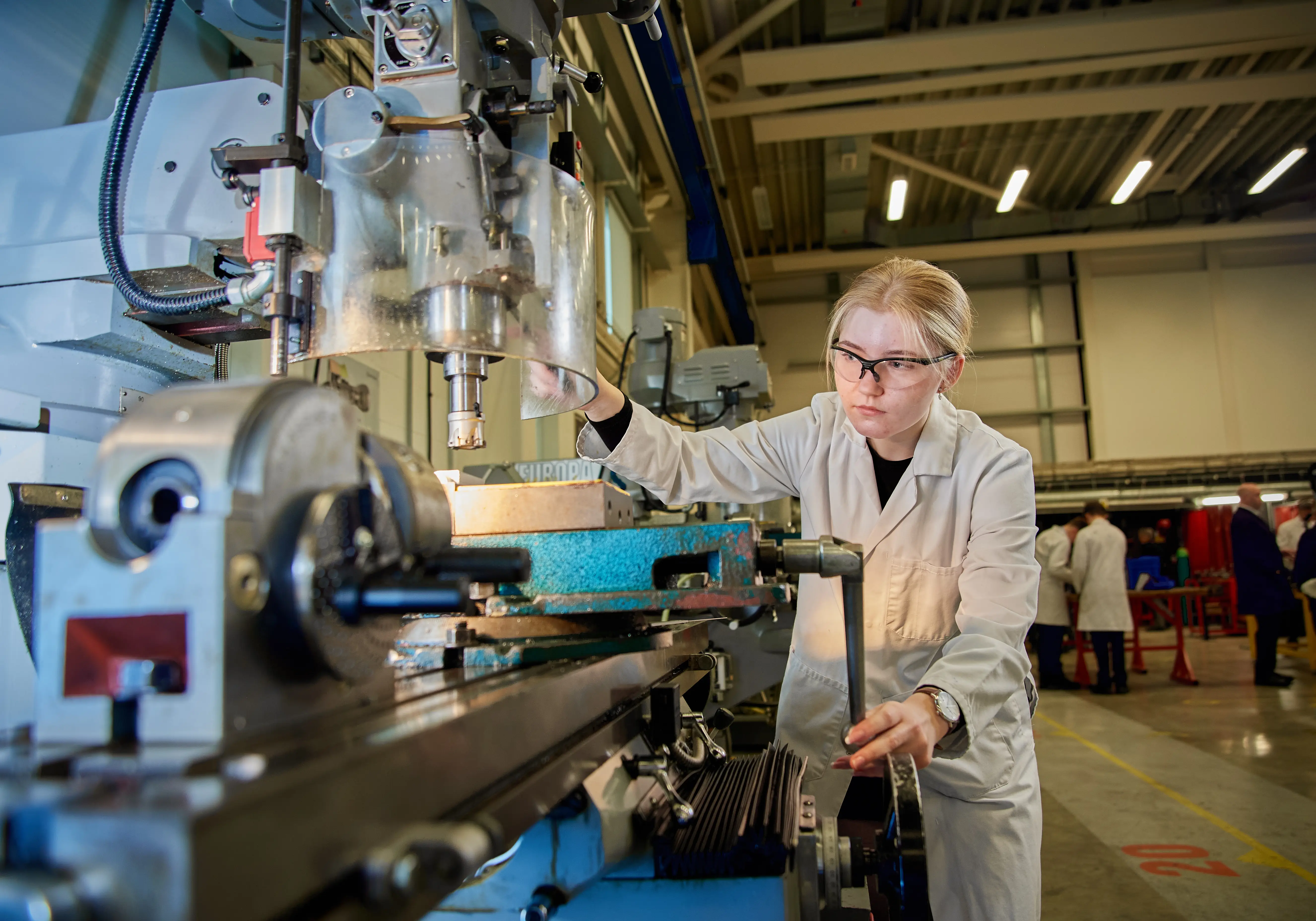 Student operating a milling machine in a technical education workshop