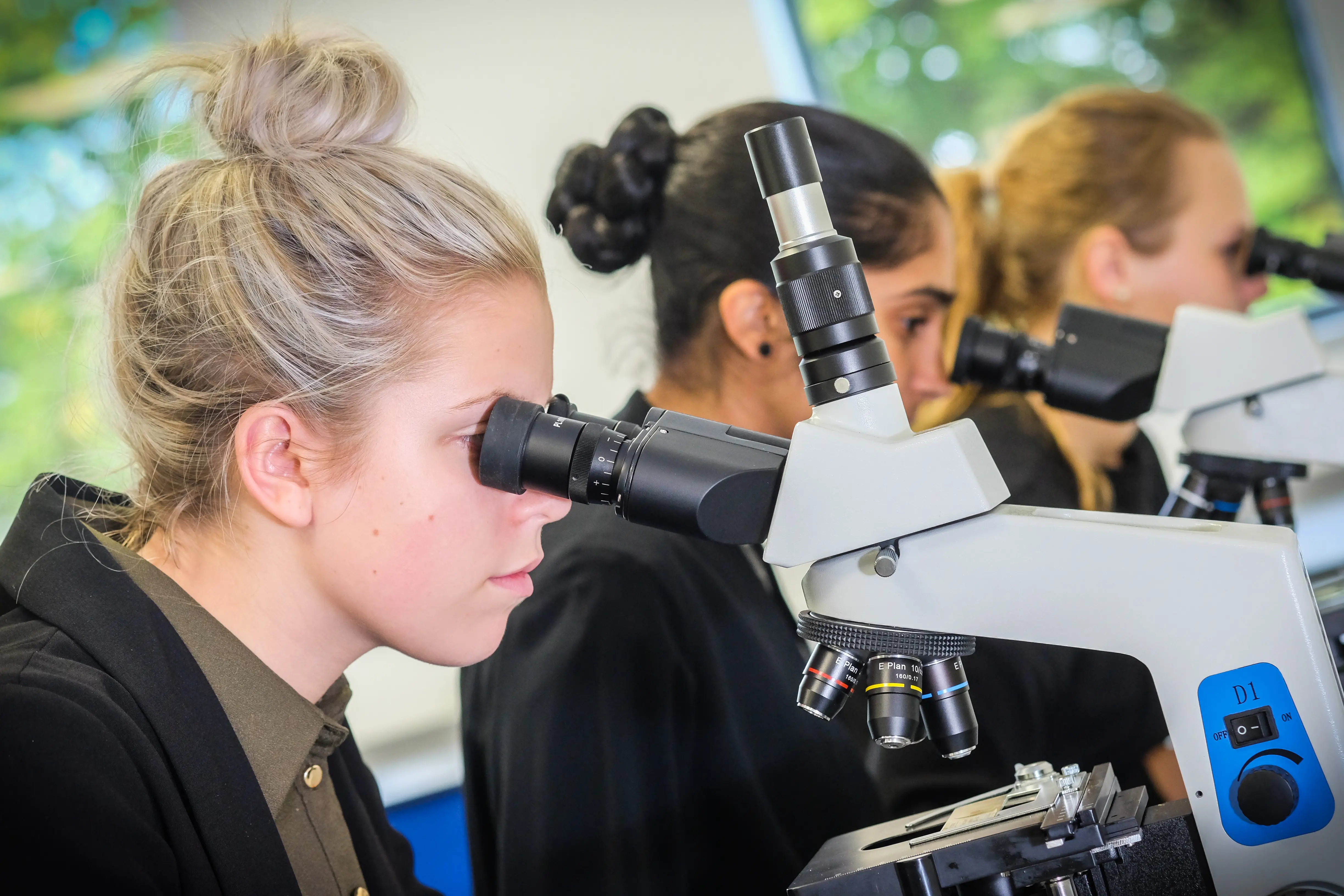 Students using microscopes in a school science lab